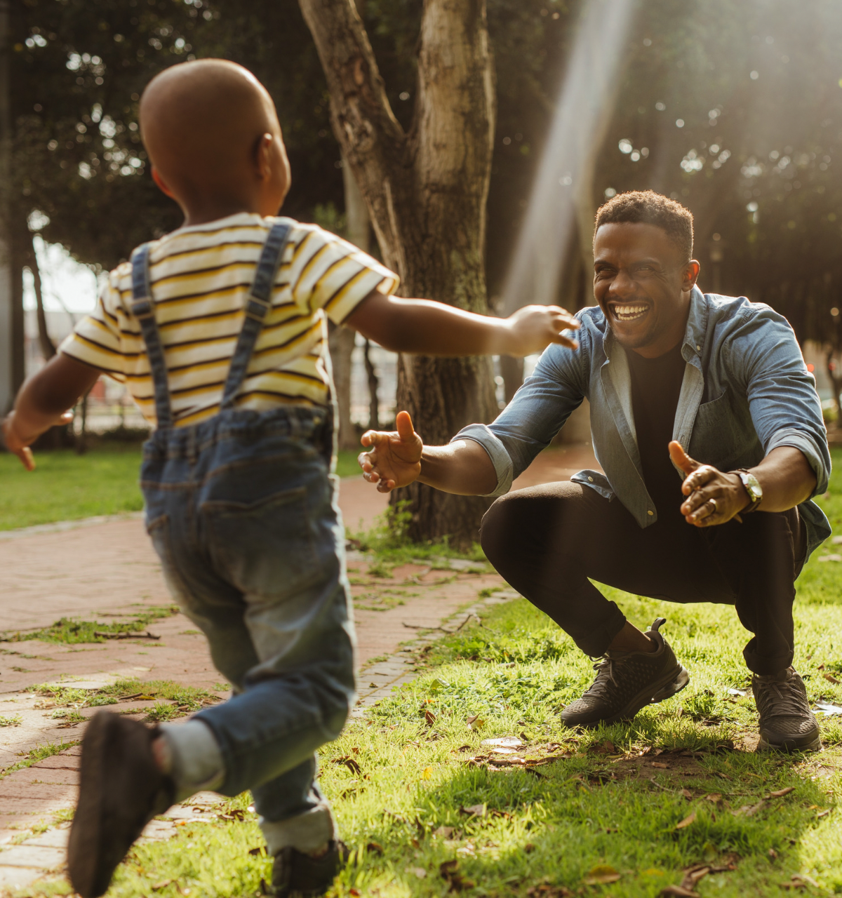 A young boy running into the arms of his father